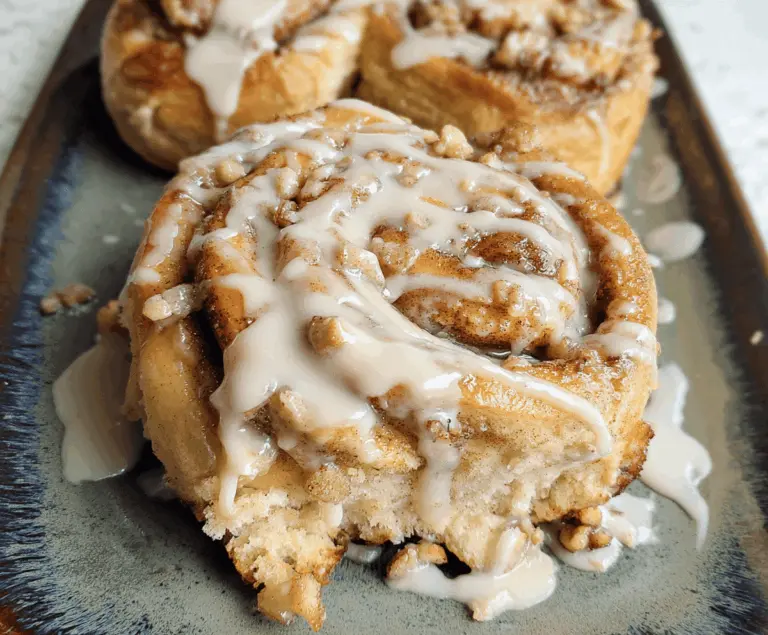 Delicious apple pie stuffed cinnamon rolls topped with icing, showcasing a warm, flaky pastry filled with cinnamon-spiced apple filling for a perfect sweet breakfast or dessert.