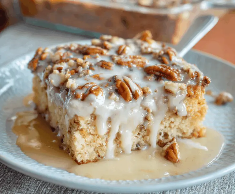 Delicious Butter Pecan Praline Poke Cake topped with toasted pecans and caramel sauce, perfect for dessert