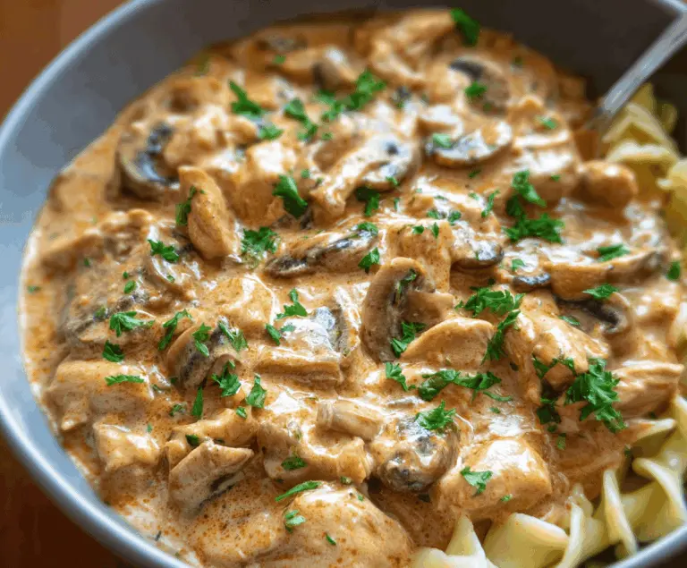 Creamy chicken stroganoff served over noodles with mushrooms and herbs, perfect for a comforting dinner.