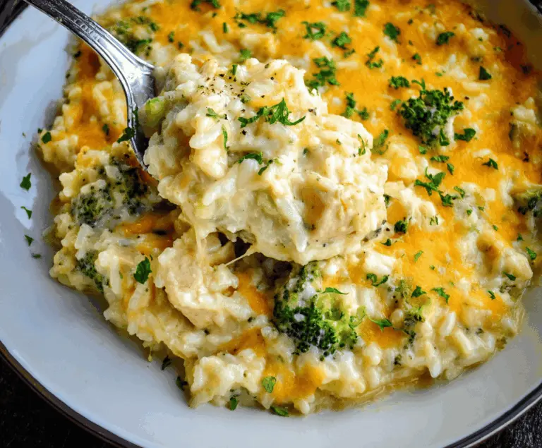 Delicious creamy chicken broccoli rice cheese casserole topped with melted cheese, served in a baking dish.