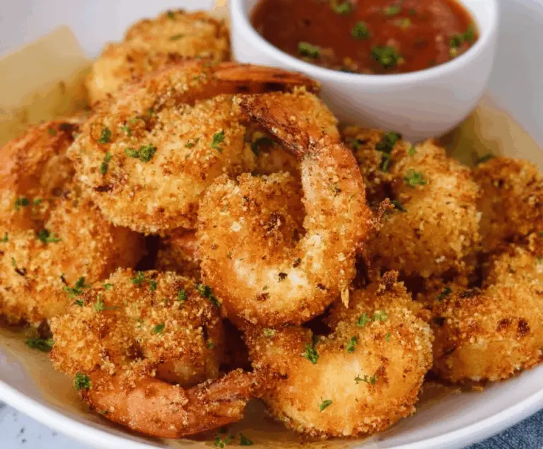 Golden crispy air fryer shrimp served with lemon wedges on a white plate, perfect for a quick and healthy seafood meal.