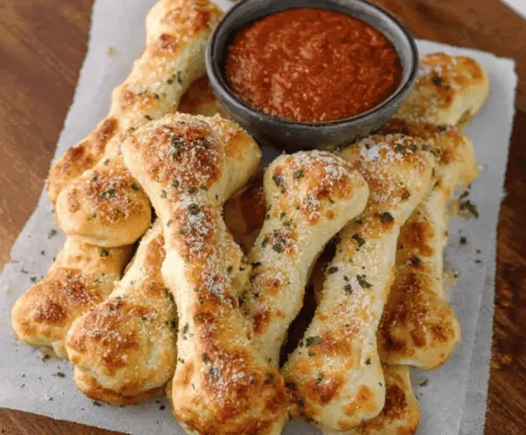 Delicious cheesy breadstick bones topped with melted cheese and herbs, served on a platter, perfect for sharing as a savory appetizer or snack.
