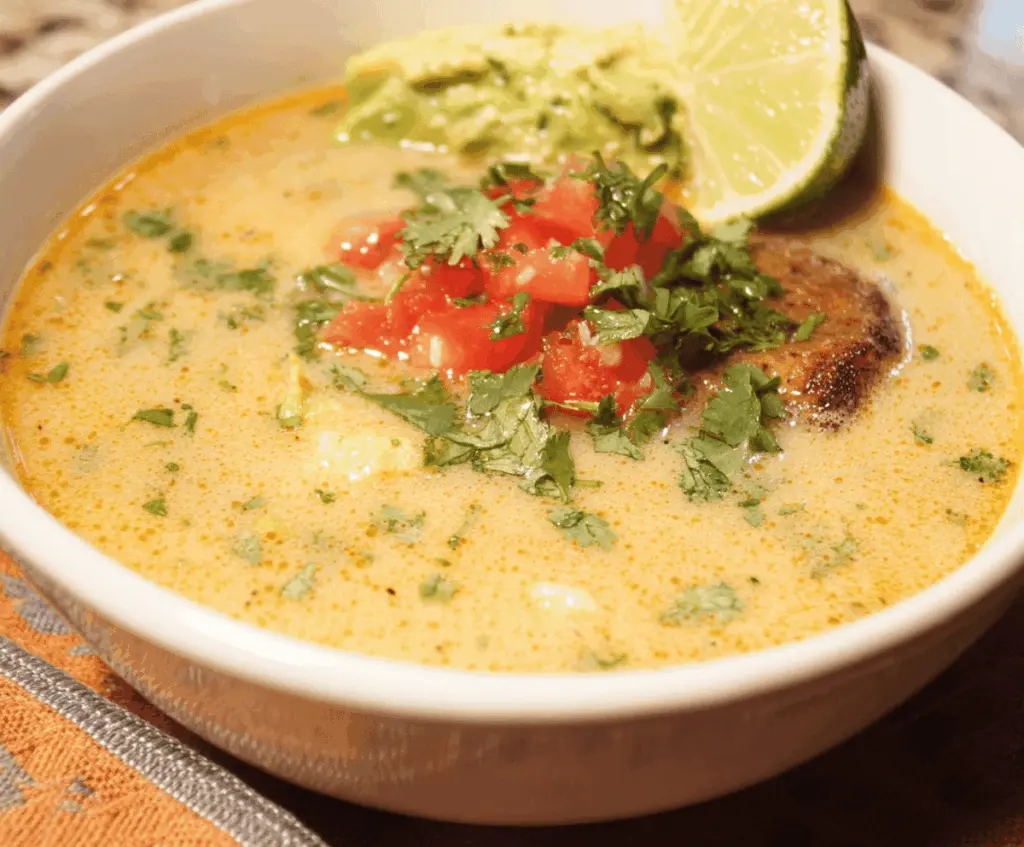Hearty Chile Relleno Soup with melted cheese and fresh chili peppers in a rustic bowl.