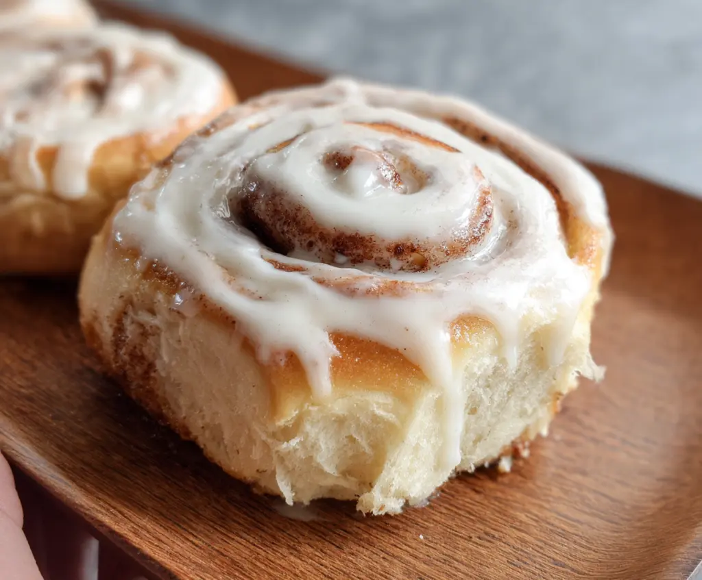 Delicious sourdough discard cinnamon rolls topped with icing on a baking tray.