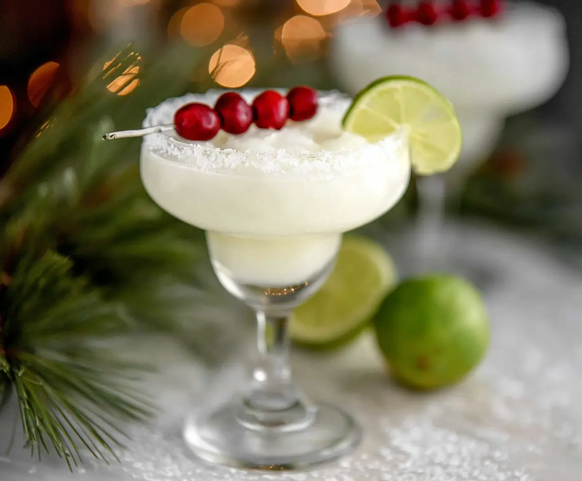 Refreshing White Christmas Margarita with a salted rim and festive garnish.