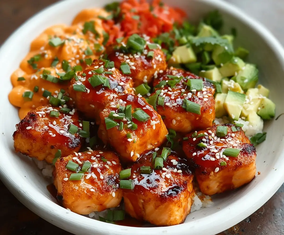 Delicious Bang Bang Salmon Bites served in colorful bowls with fresh vegetables and Asian-inspired sauce.