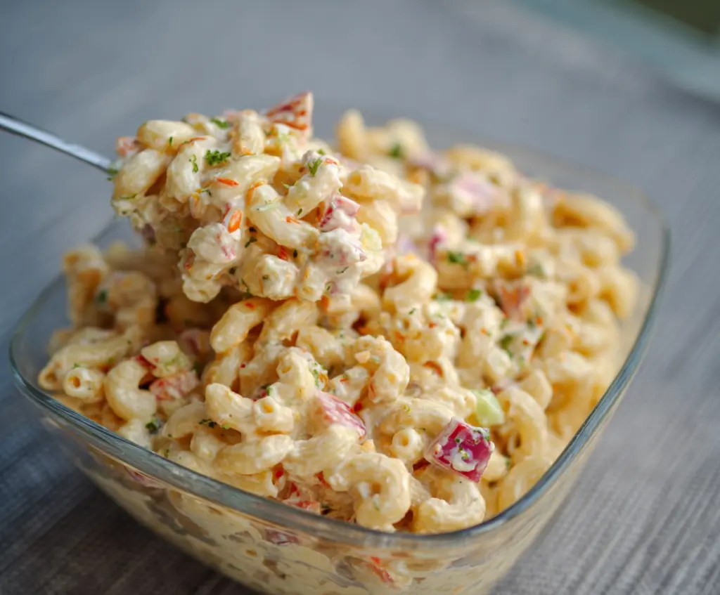 Delicious Guy Fieri's Famous Mac Salad with pasta, creamy dressing, and herbs on a plate.
