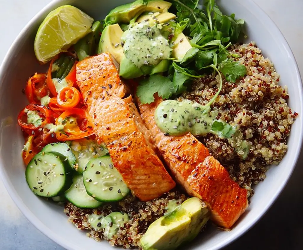 Healthy salmon and quinoa power bowl filled with fresh vegetables and vibrant herbs.