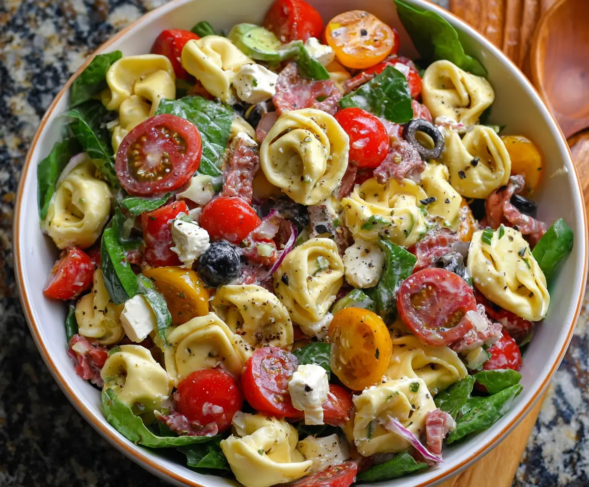 Colorful tortellini pasta salad with fresh vegetables and herbs, perfect for summer meals.